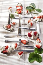 Presentation of the strawberries with cream spoons on various