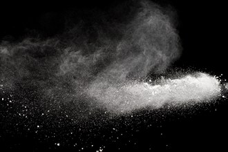 Bizarre forms of white powder explosion cloud against black background.White dust particles splash