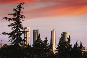 Madrid, Spain, September 11, 2021: Cuatro Torres Financial District at dramatic red color sunrise,