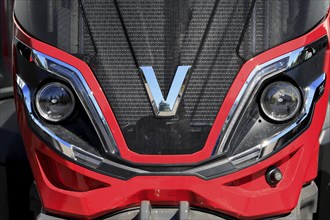 Valtra logo on the front of a red, modern Valtra farm tractor. Salo, Finland. June 23, 2024