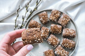 Female hand hold Oat cookies, oat dates energy, selective focus. Vegan sweets. Homemade bakery. Raw