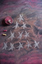 Small stylized christmas tree on blackboard with chalk