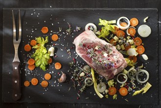 Presentation of a pork shank on stone slate