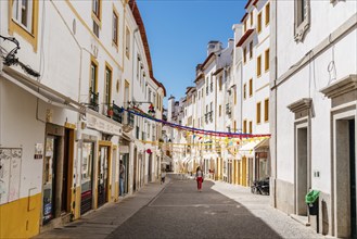 Evora, Portugal, June 30, 2022: Street in the old town with typical whitewashed houses with