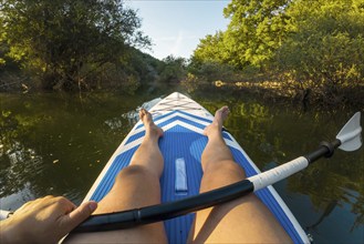 Kayaking in lake. POV of man kayaking in beautiful landscape. Aquatic sports during summer concept.