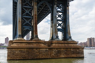 Detail of Pillar of Manhattan Bridge against cityscape of New York City. Steel Abutment With Bolt