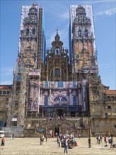 Western facade of the cathedral behind scaffolding and mural panels during restoration, Santiago de