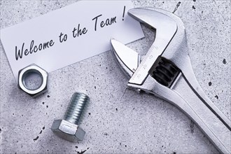 The photo shows a label with the inscription 'welcome to our team' with a spanner and screw on a