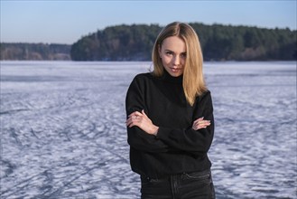 Young female smiling and looking at a camera in a snow landscape. Happy hipster girl with hip hop