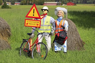 Funny arrangement of an couple with safety vests on alerts motorists of the Hiiden koulu school