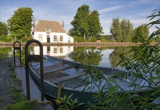 View over a rowing boat at the ferry house in Overschie along the canal Delftse Schie between the