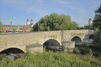 Historic Old Elster Bridge with church towers of the over the White Elster, river, stone arch