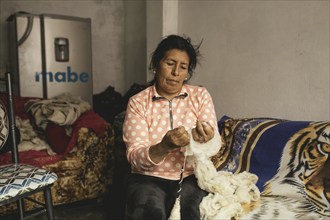 Portrait of a miner weaving in her house, Cachapalca, Peru, South America