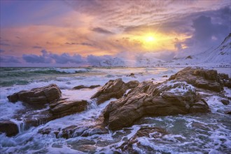 Waves of Norwegian sea on rocky coast in fjord on sunset with sun. Skagsanden beach, Lofoten