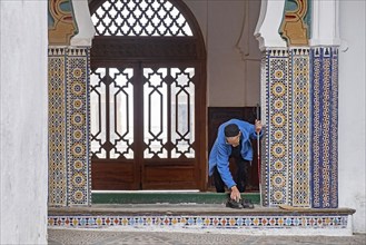 Elderly Muslim man putting his shoes back on when leaving the Great Mosque, Jamaa el Kebir in