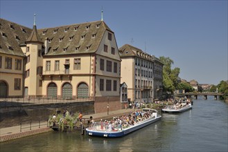 Excursion boat with tourists in front of the old slaughterhouse, Ancienne Boucherie, on the River