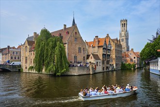 Bruges, Belgium, May 29, 2018: Tourist boat passin in famous Bruges tourist landmark, Rozenhoedkaai