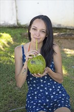 Brazilian woman, 26, drinking from coconut, Salvador, Bahia State, Brazil, South America