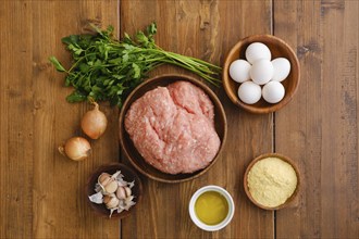 Top view of minced meat and ingredients for homemade meatballs on a table