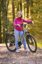 Woman on Ebike through the autumn forest, Black Forest, Gechingen, Germany, Europe