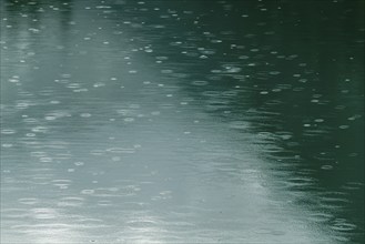 Raindrops on emerald green reservoir, Stillup reservoir, Stilluptal, Mayrhofen, High Mountain