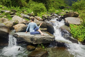 Yoga exercise outdoors, woman doing Ardha matsyendrasana asana, half spinal twist pose at tropical