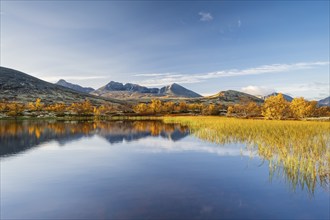 Reflection of the autumn landscape in Rondane National Park, mountains Høgronden, Midtronden and