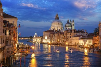 View of Venice Grand Canal with boats and Santa Maria della Salute church in the evening from Ponte