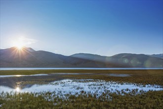 Lake Tso Moriri in Himalayas on sunrise. Ladakh, Inda. With lens flare