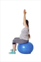 Pregnancy exercise concept, pregnant woman doing exercises with exercise ball isolated on white