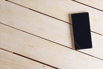 Top view of smartphone on empty wooden table