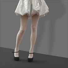 Slim female legs in knitted white tights. Photo with clipping path