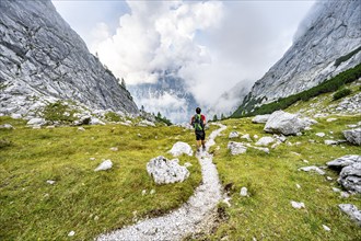 Mountaineer on a hiking trail, cloudy mountains, descent over the Ofental, mountain tour on the