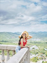 Happy tourist woman in hat on a viewpoint. Portrait of vacationer girl in a viewpoint. Travel and