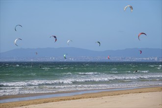 Kiteboarding kitesurfing kiteboarder kitesurfer kites on the Atlantic ocean beach at Fonte da Telha