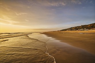 Atlantic ocean sunset with surging waves at Fonte da Telha beach, Costa da Caparica, Portugal,