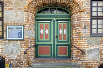 Historic door richly decorated with ornamentation and carvings of the heritage-protected building