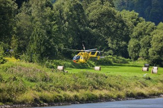 An ADAC rescue helicopter attempts to land on the banks of the Elbe in Schöna in Saxon Switzerland