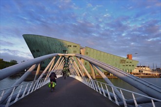 AMSTERDAM, NETHERLANDS, MAY 9, 2017: NEMO Science museum and Mr. J. van der Veldebrug bridge. It is