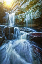 Tropical waterfall with sun rays. With lens flare and light leak