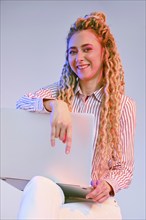 Smiling young woman shows the comfortability of using wireless technology