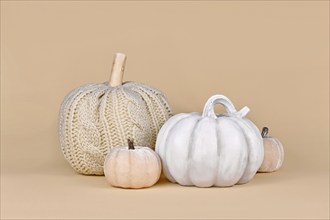 Autumn decoration with boho style knitted beige pumpkin and gray stone pumpkin