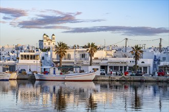 View of Naoussa, Fishing boats in the harbour at sunset, reflected in the sea, White Cycladic