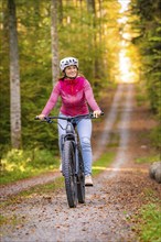 Woman on Ebike through the autumn forest, Black Forest, Gechingen, Germany, Europe