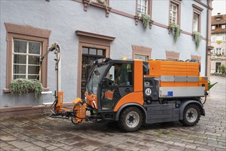 A multifunctional vehicle waters flower boxes in the old town of Engen