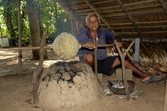 Man of a Caboclos tribe heating up a rubber ball, Amazon state, Brazil, South America