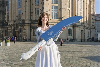 Stollen girl Lisa Straßberger presents the giant stollen knife in front of the Church of Our Lady