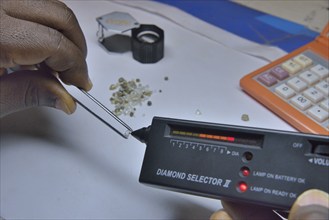 Diamond dealer inspecting a diamond for its authenticity, Koidu, Koidu-Sefadu, Kono District,