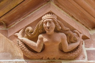 Supporting and ornamental architectural detail in the form of a bare-breasted mermaid on the