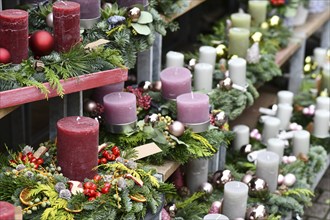 Traditional advent wreaths with single big dark red, pink and white candles and seasonal Christmas